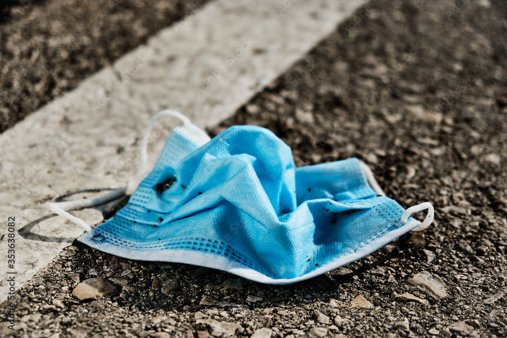 used surgical mask thrown on the asphalt used surgical mask thrown on the asphalt