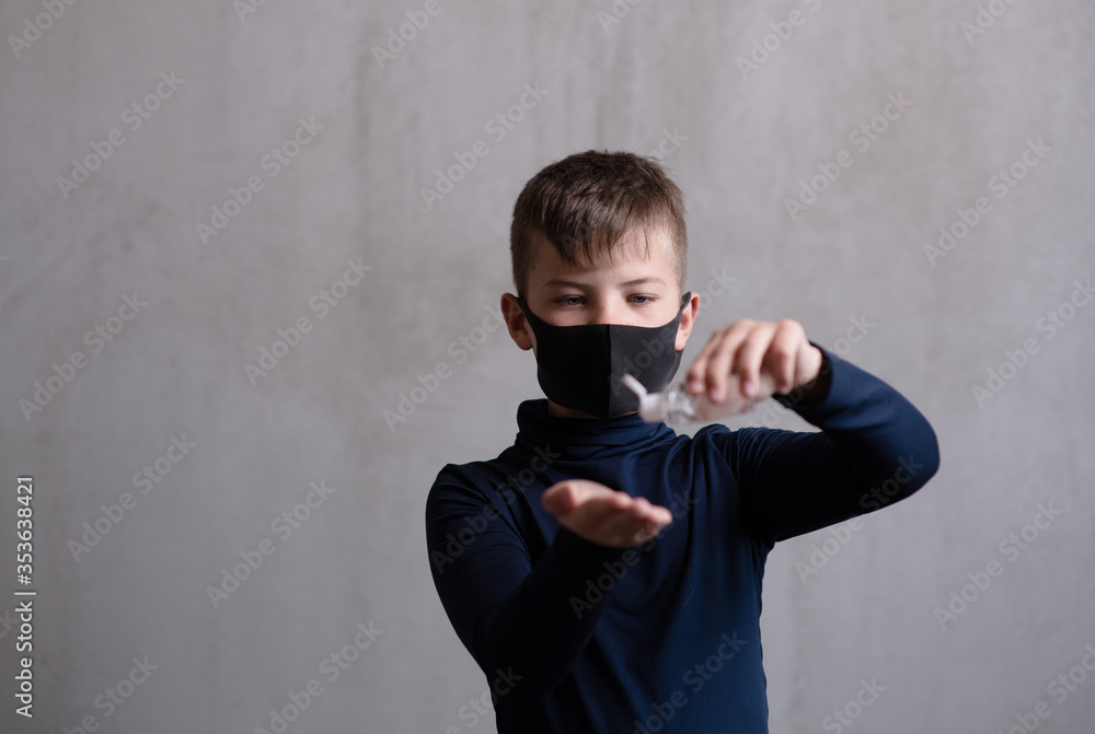 A child in a black medical mask treats his hands with alcohol-containing gels. Hygiene rules during a pandemic concept A child in a black medical mask treats his hands with alcohol-containing gels. Hygiene rules during a pandemic concept