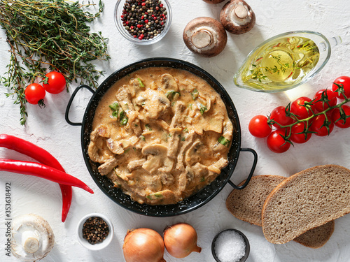 Tasty beef stroganoff with products on white background photo