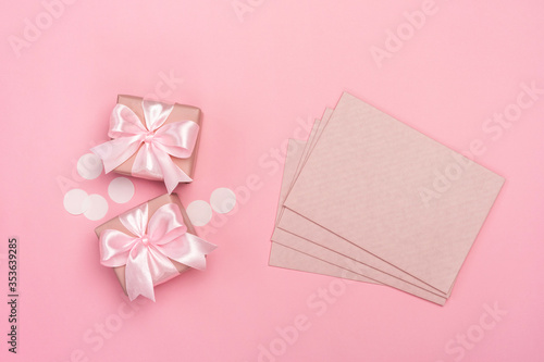 Two gifts or presents boxes decorated with confetti and envelope on pink pastel background. Top view with copy space. Flat lay composition for birthday or wedding.  © kaloriya