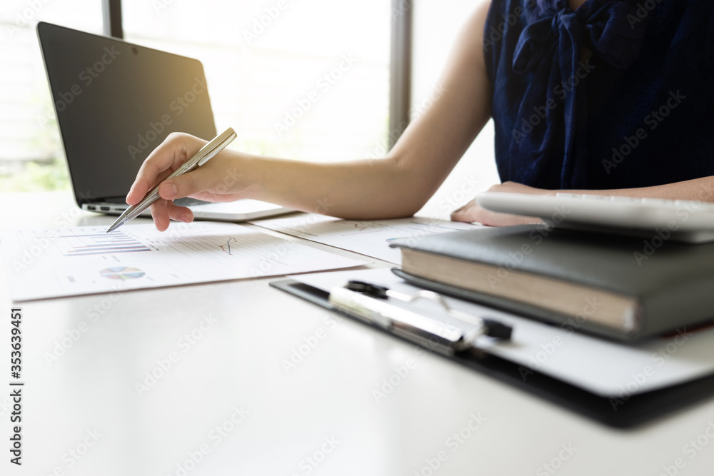Business women is analyzing marketing strategy from the selling performance graph in the room and work from home. Business women is analyzing marketing strategy from the selling performance graph in the room and work from home.