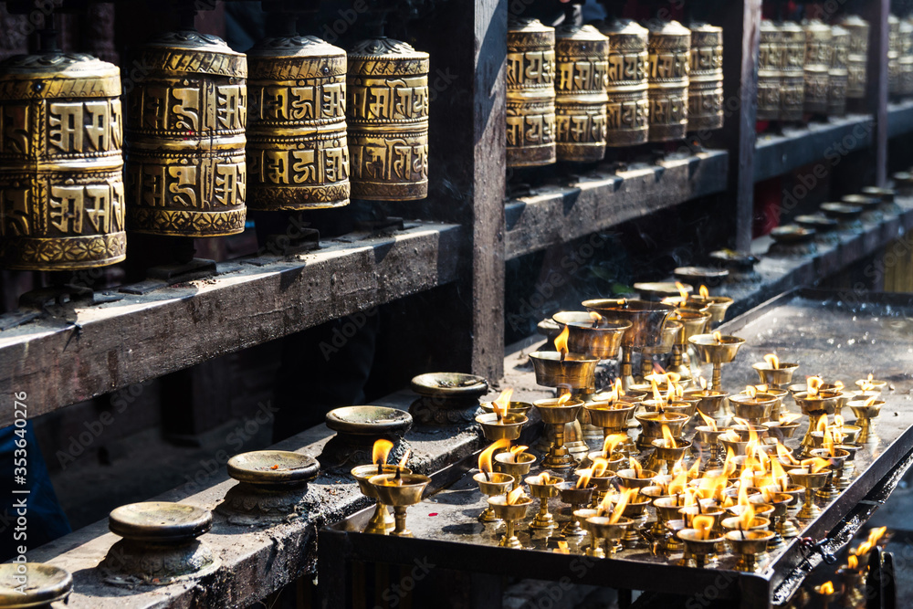 Prayer wheels and butter lamps in the courtyard of Kwa Bahal or Golden Temple, Patan, Nepal