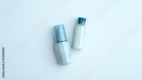 Blue cosmetic bottles with water based natural SPA lotion. Hyaluronic acid collagen beauty products. Flat lay, top view.
