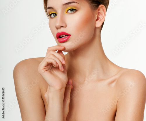 Beautiful face of young adult woman with bright makeup.  Looking at Camera.