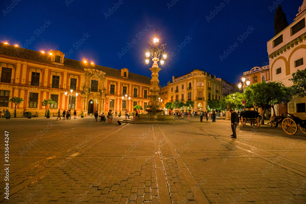 Night view of the Plaza Virgen de los Reyes with the Giralda and the cathedral of Seville, Spain.
