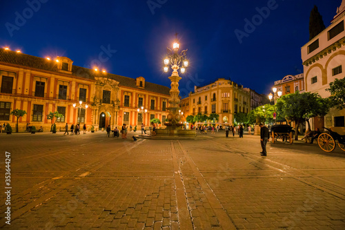 Night view of the Plaza Virgen de los Reyes with the Giralda and the cathedral of Seville, Spain.