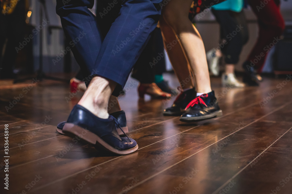 Dancing shoes of young couple dance retro jazz swing dances on a ballroom club wooden floor, close up view of shoes, female and male, dance lessons Dancing shoes of young couple dance retro jazz swing dances on a ballroom club wooden floor, close up view of shoes, female and male, dance lessons