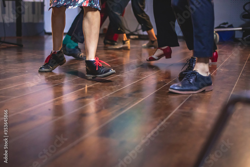 Dancing shoes of young couple dance retro jazz swing dances on a ballroom club wooden floor, close up view of shoes, female and male, dance lessons