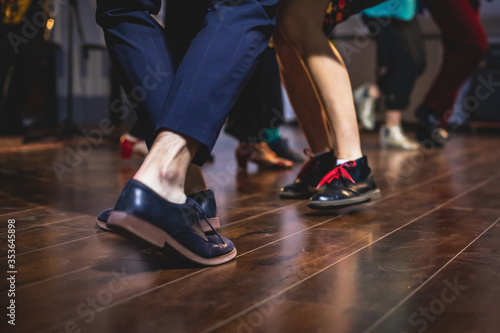 Dancing shoes of young couple dance retro jazz swing dances on a ballroom club wooden floor  close up view of shoes  female and male  dance lessons