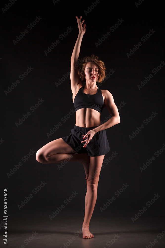 Young girl doing yoga on a black background Young girl doing yoga on a black background