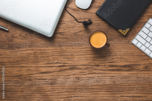 Business background concept. Flat lay composition with coffee, keyboard,.lapel microphone, notepad and other office related objects ob wood background