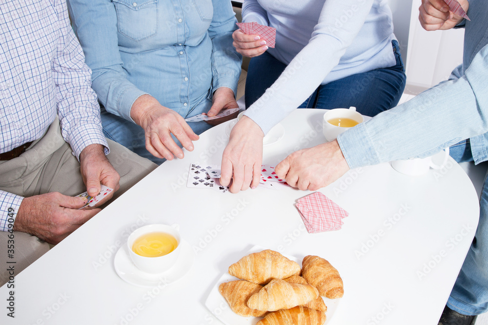 Elderly couple playing cards with their family hands close up Elderly couple playing cards with their family hands close up