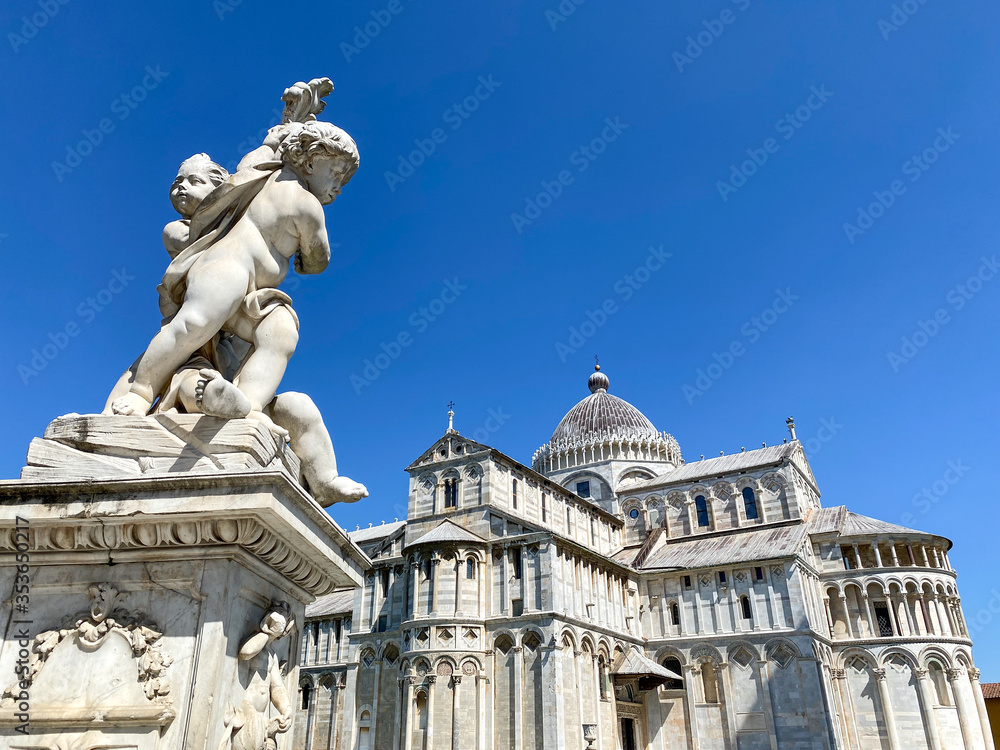 Cherub statue that sits on the Field of Miracles in Pisa, Tuscany. Famous Cathedral in the background