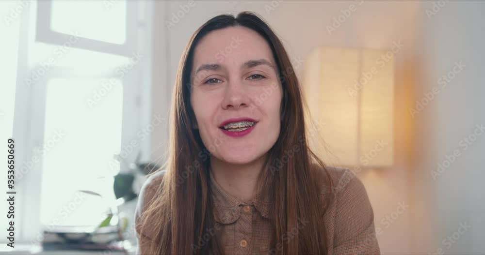 Portrait of young attractive 30s brunette Caucasian woman talking, looking at camera. Webcam conference call concept.