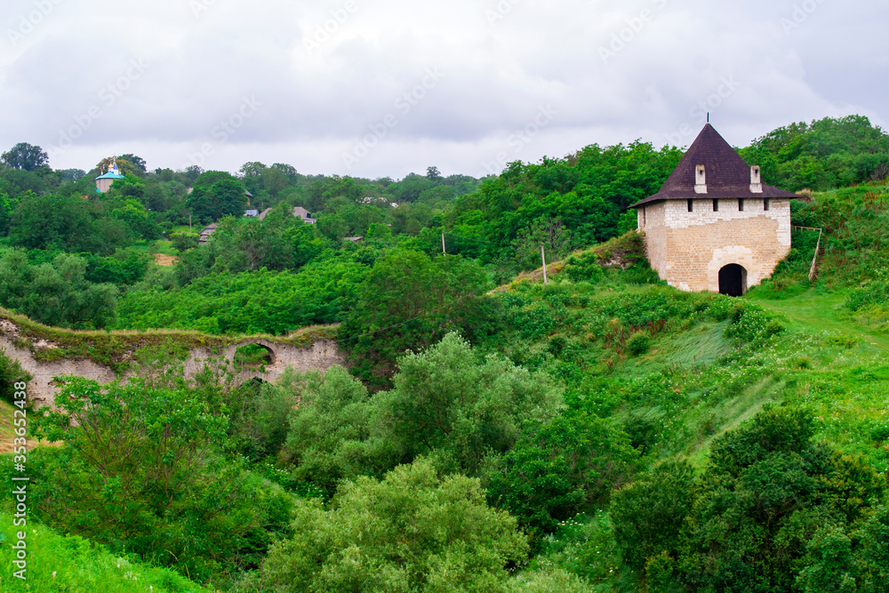 Old medieval fortress among green hills and trees