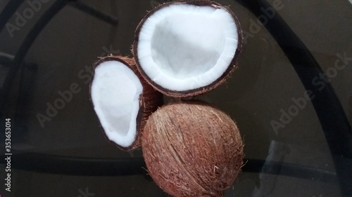 View of entire ripe unhusked Coconut and split coconut (Cocos nucifera) of Arecaceae family. photo