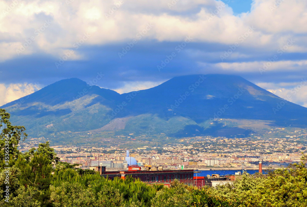 Landscape with City of Naples and Vesuvius vulcan in background with cloudy blue sky, Naples Italy 