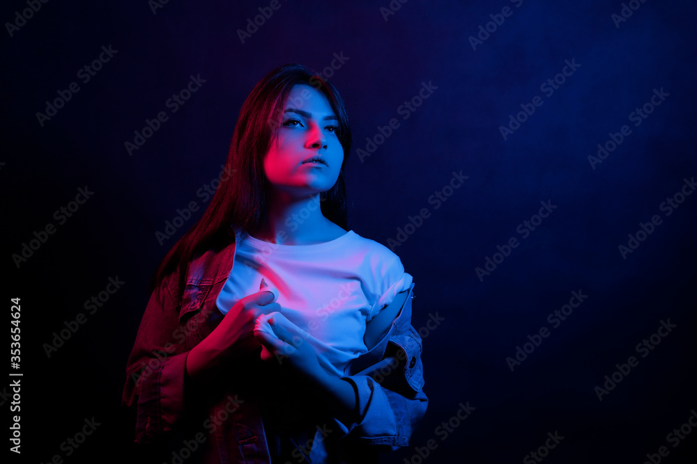 The girl with long hair and neon lights. Trend neon light. The concept of the psychological problems of the teenager.