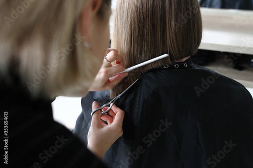 Hairdresser cutting hair in salon closeup