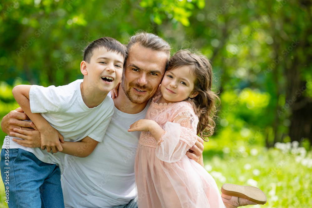 Happy beautiful family together father, son and daughter portrait on a walk on a Sunny summer day Happy beautiful family together father, son and daughter portrait on a walk on a Sunny summer day
