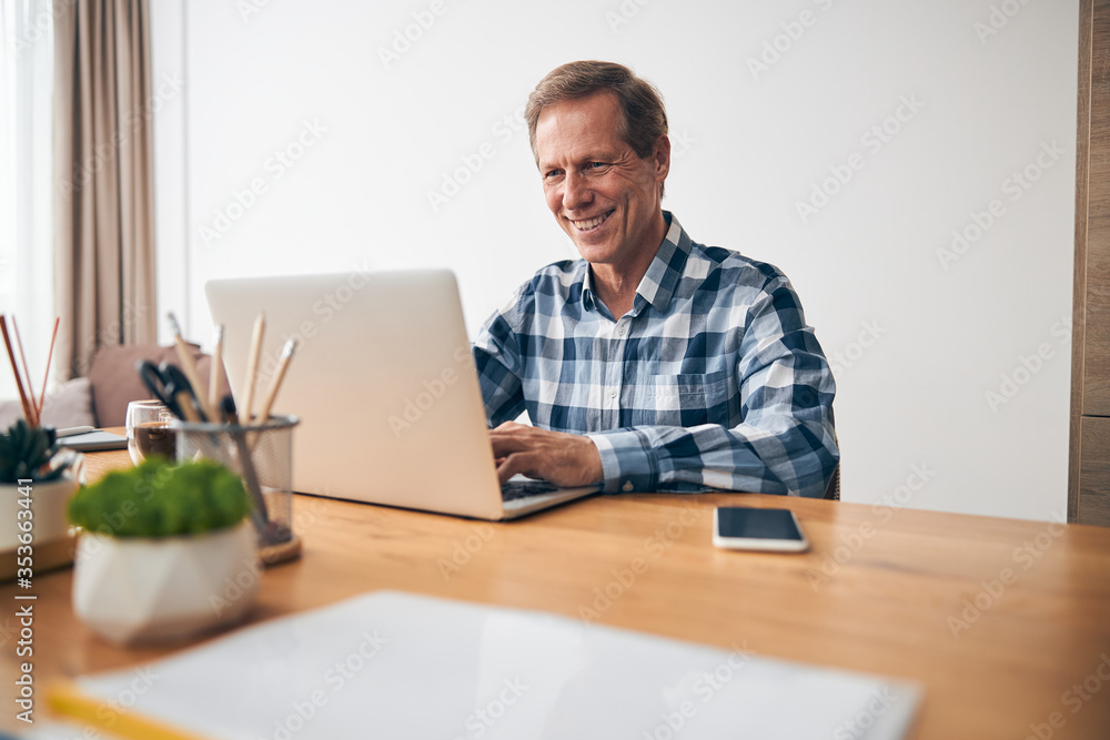 Handsome mature worker staring at screen of his computer Handsome mature worker staring at screen of his computer