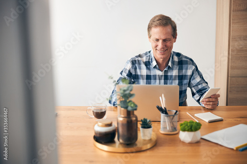 Cheerful male person looking at his laptop
