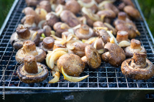 Make, fry mushrooms with onion rings on grill. Vegan food.