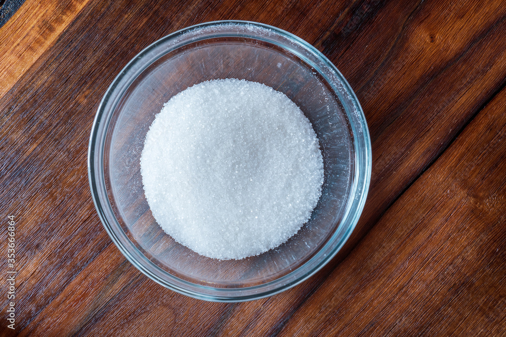 Sugar in bowl isolated on wooden