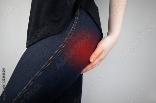 A woman suffers from pain in the buttock. The doctor diagnoses the patient piriformis syndrome, pinch of the sciatic nerve, lumbar osteochondrosis or sciatica photo