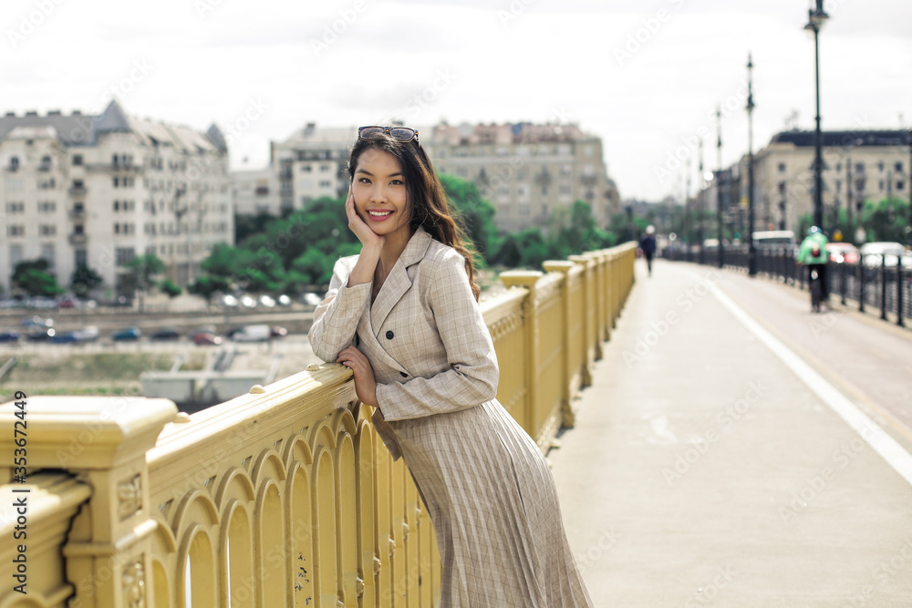 Fototapeta premium Elegant woman is walking in the city