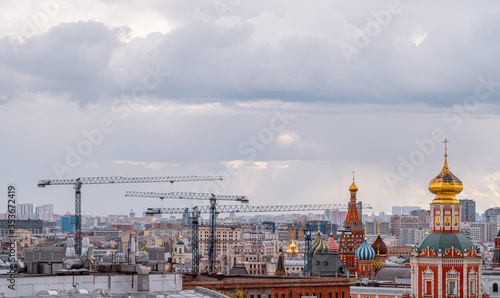 The historical center of Moscow and construction cranes. St. Basil's Cathedral from above. City panorama.