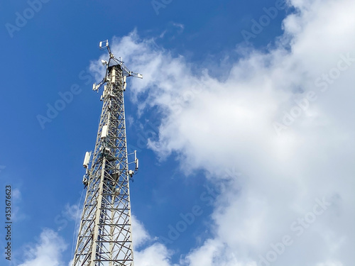 Cellular Base Station or Base Transceiver Station. Telecommunication tower. Wireless Communication Antenna Transmitter. 3G, 4G and 5G Cell Site with blue and cloudy sky.