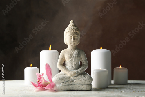 Composition with buddha and candles on wooden table. Zen concept