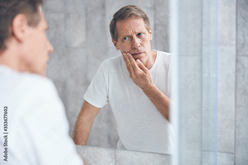 Sad man staring at his own reflection Sad man staring at his own reflection