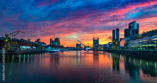 Puerto Madero Bridge and city by the river  during sunrise  with colorful clouds. 