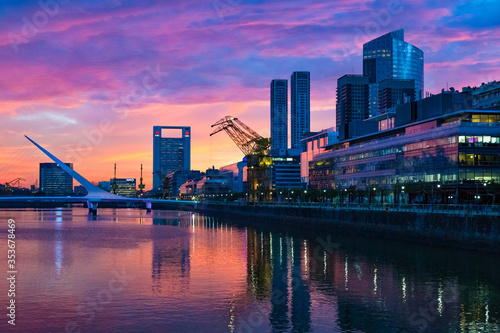 Puerto Madero Bridge and city by the river, during sunrise, with colorful clouds.  photo