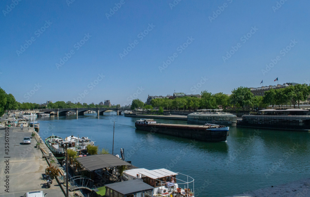 view of the Seine river and boats on it with a bridge in Paris