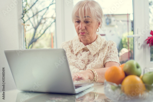 Beautiful senior woman using laptop at home.
