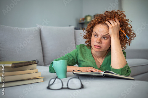 Obraz na plátne Frustrated woman worried about problem sitting near sofa