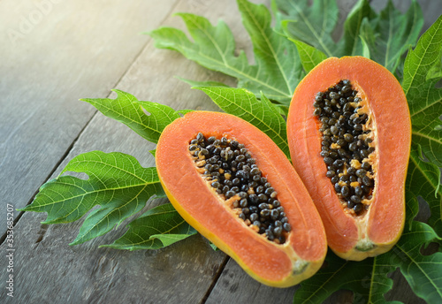 Half cut papaya placed on a wooden background.Papaya fruit on wooden background.close up papaya image. 