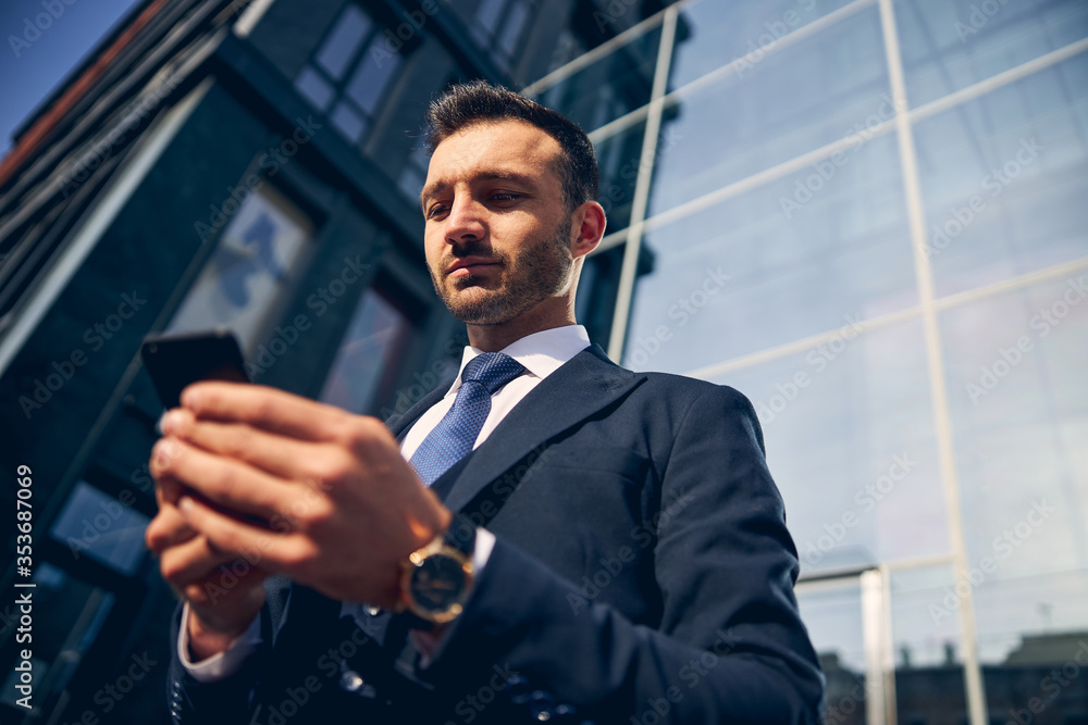 Handsome brunette man standing near big building Handsome brunette man standing near big building