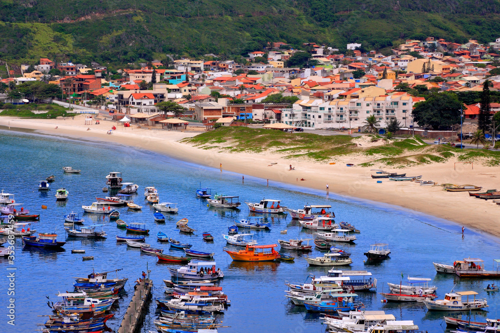 aerial view of beach with colorful fishing boats and little town. Arraial do cabo, Brazil.