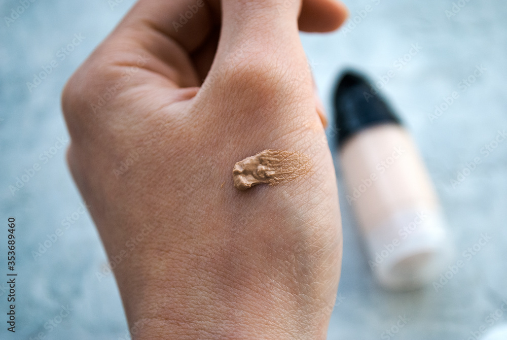 Foundation on the hand. Woman picks a shade of foundation. Foundation on the hand. Woman picks a shade of foundation.