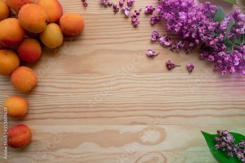 Natural background  apricots and lilac flowers on a wooden table