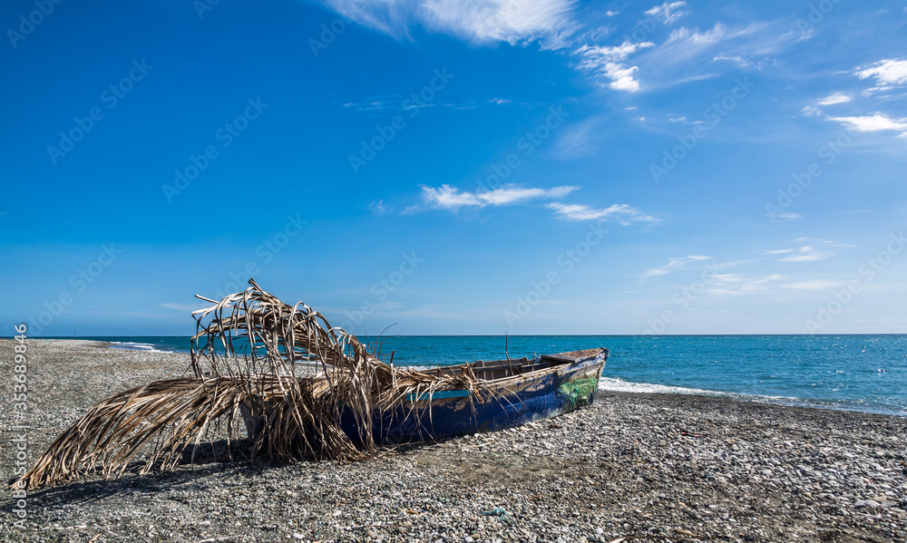 dramatic caribbean landscape of a old wooden fishing boat on the coast of the dominican republic. dramatic caribbean landscape of a old wooden fishing boat on the coast of the dominican republic.