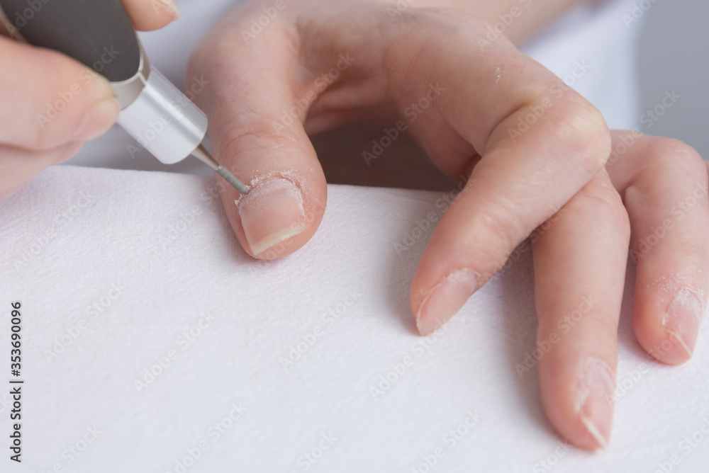 Home manicure. The care and treatment of the nails using a special  apparatus. Self-care for nails, quarantine during the pandemic. foto de  Stock | Adobe Stock
