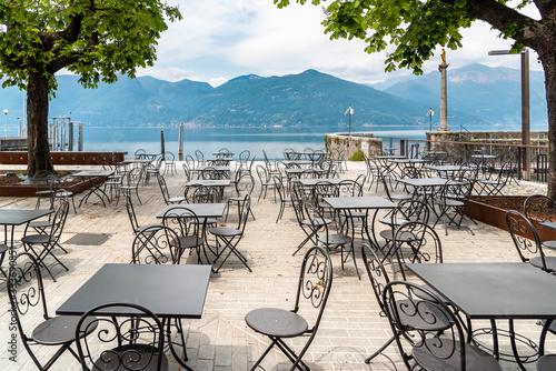 Tables and chairs of street cafe on lake Maggiore lakefront in Luino  Italy