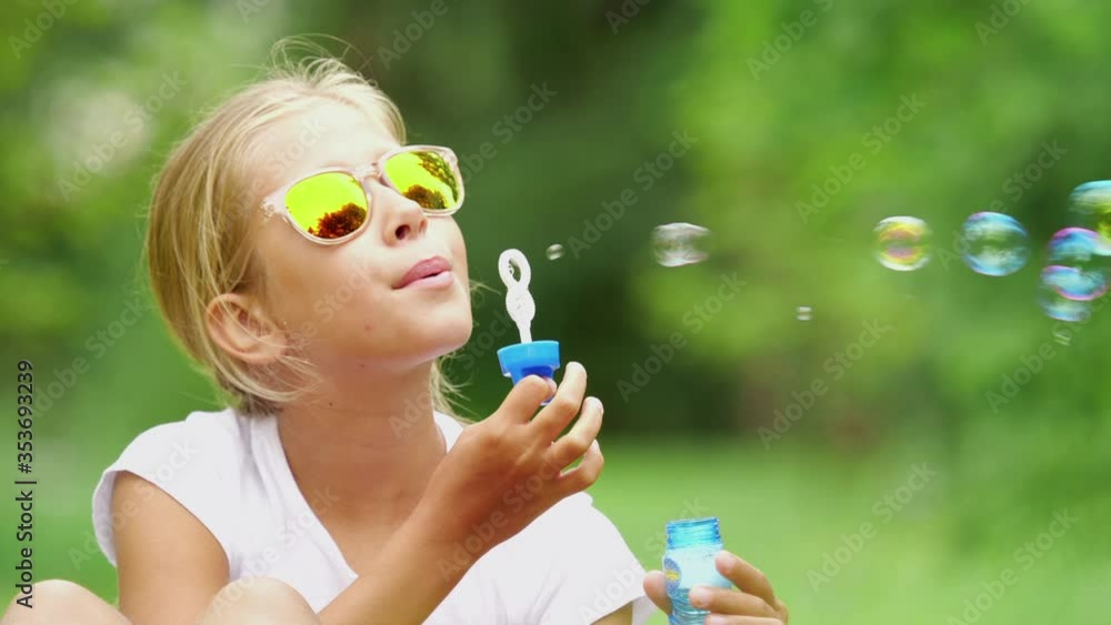 Girl playing with soap bubbles outdoor. Slow motion. Girl playing with soap bubbles outdoor. Slow motion.