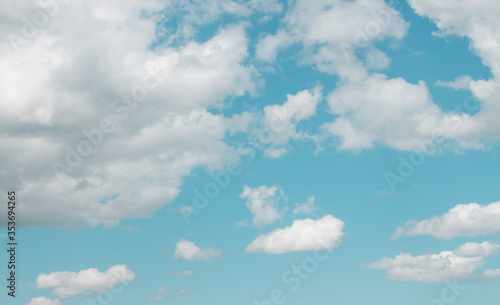  White clouds on a blue summer sky in one plane. Light skies with light fluffy clouds