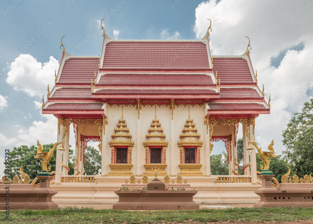 Thai temple against a blue sky and white clouds, in Buriram province